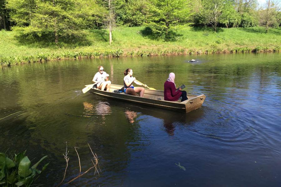 three students in a boat on Lake Agnes